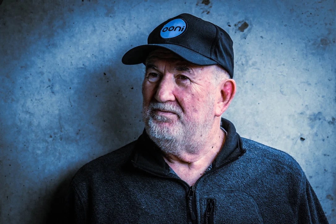 Tony Klinger in a cap, against a dark blue wall