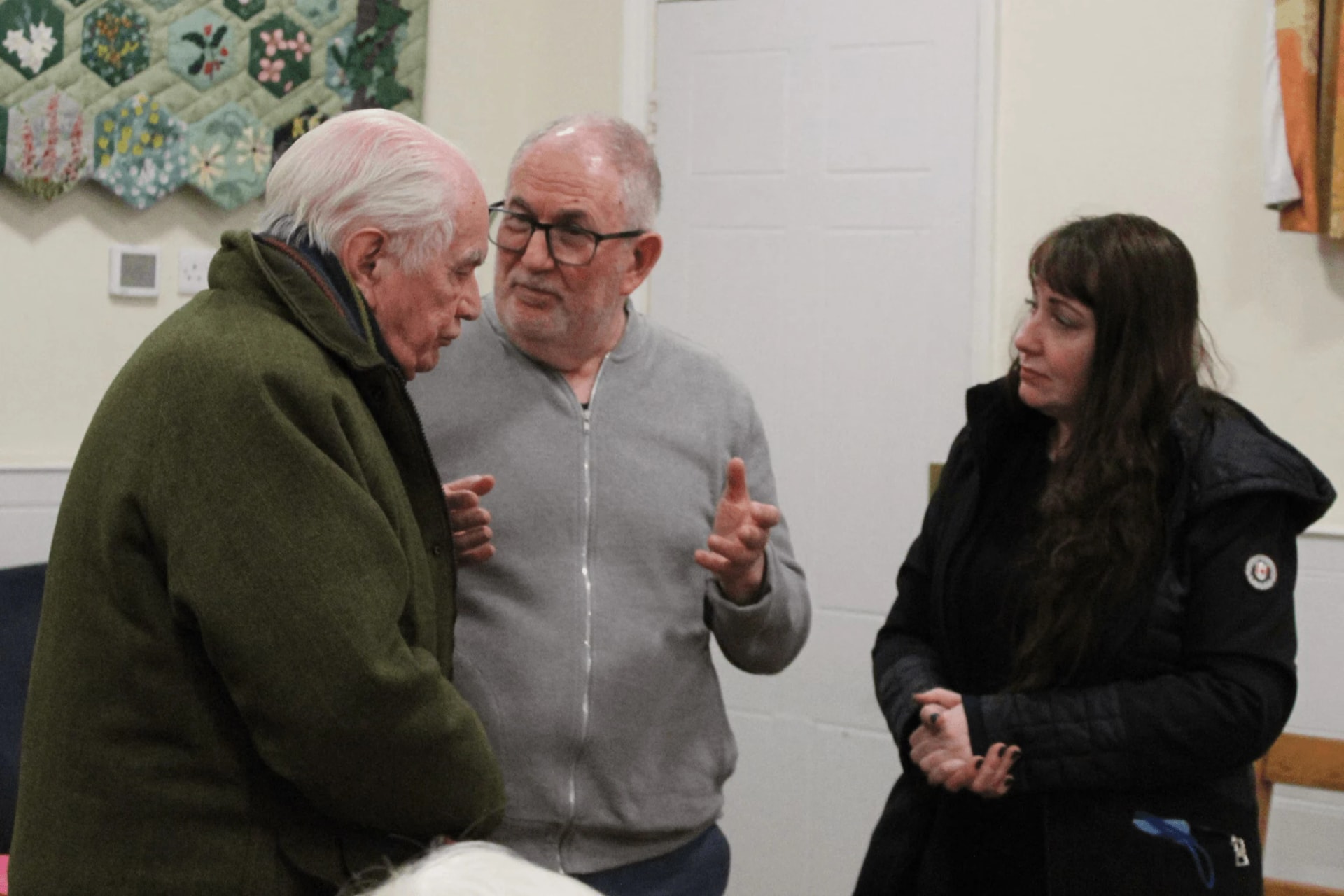 Tony Klinger in conversation with two people in a small room after a talk