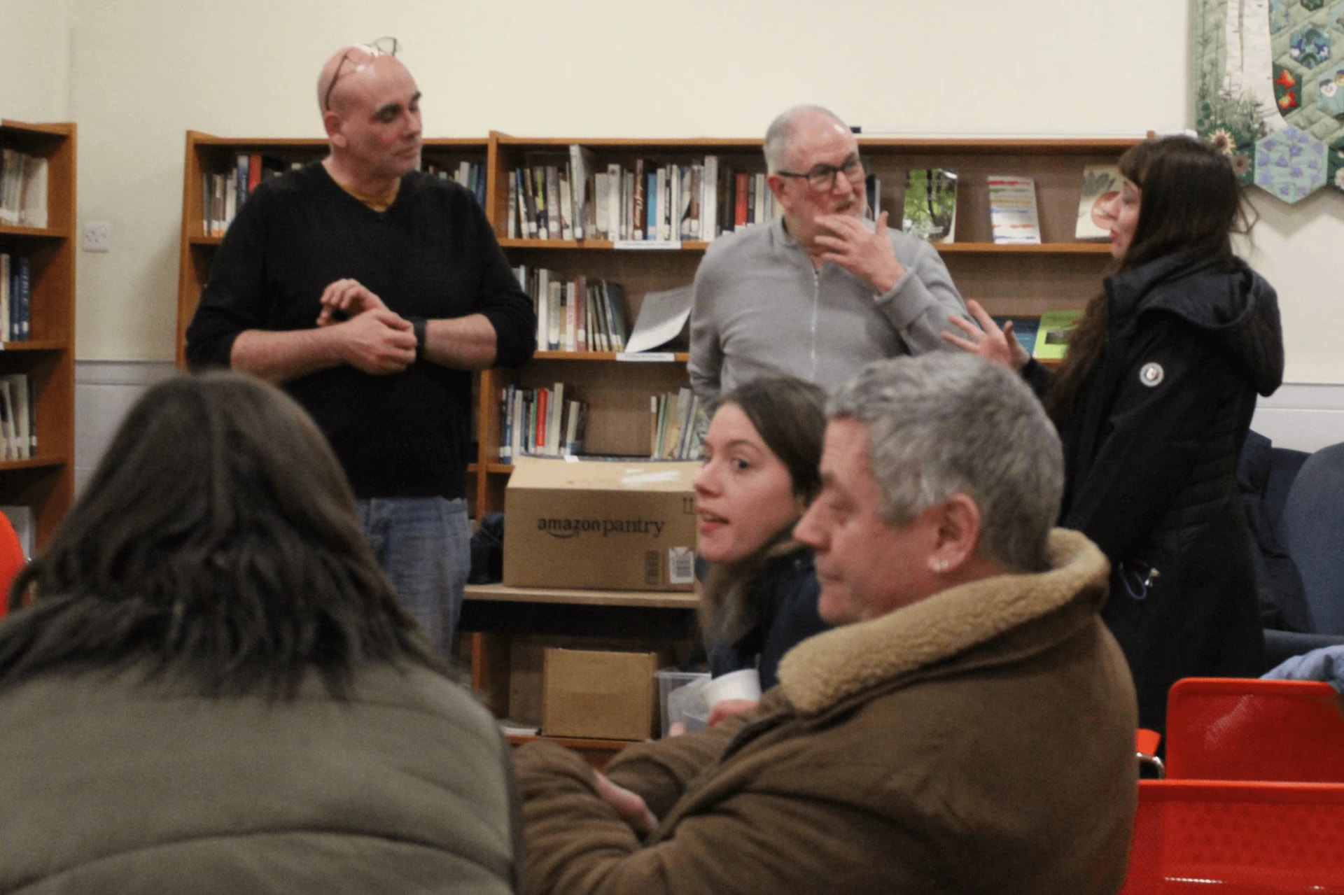 Tony Klinger standing among a small group after a talk, listening